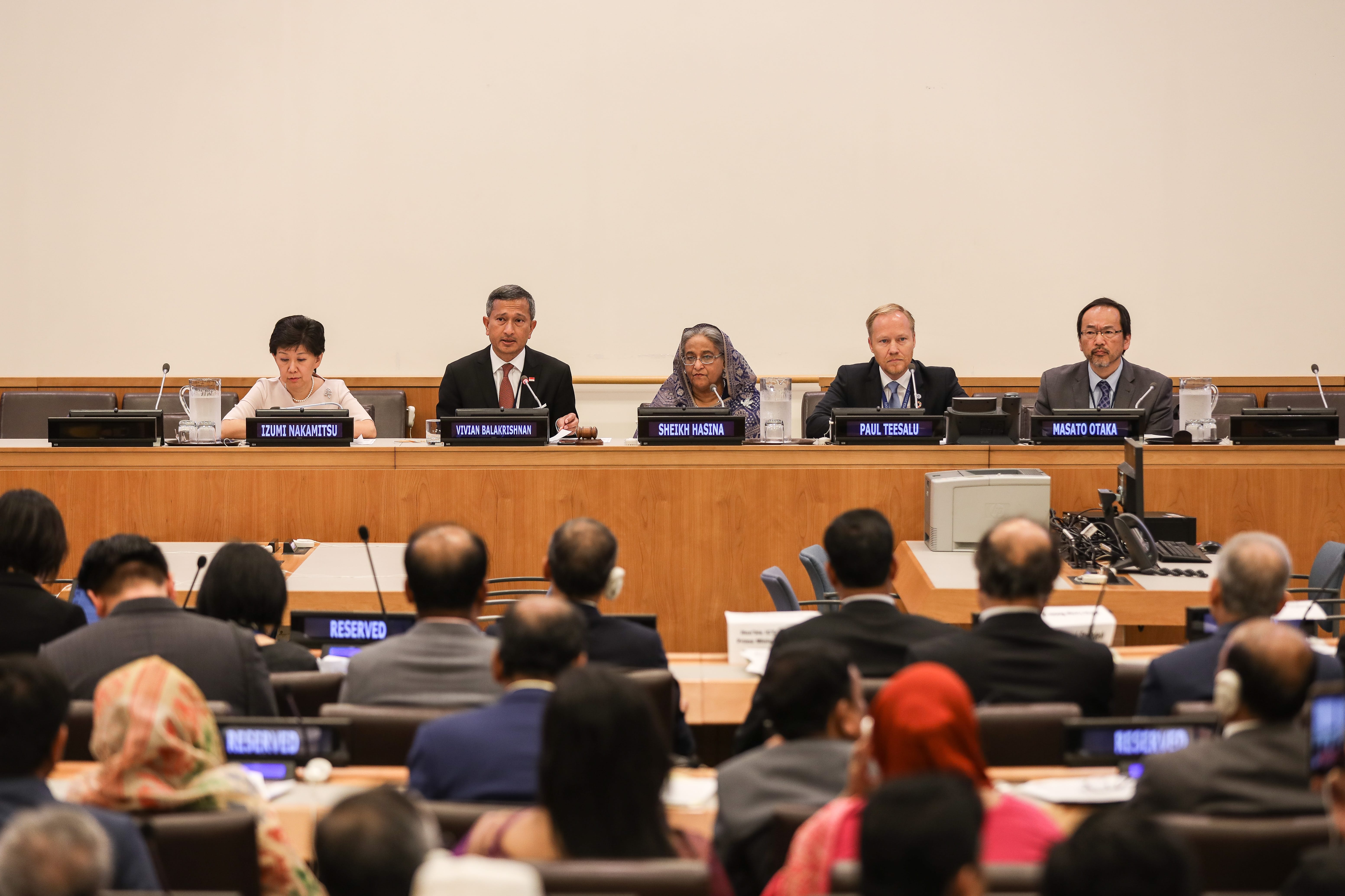 Panel of five speakers including Sheikh Hasina, with audience in foreground.
